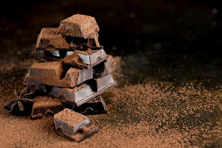 喷溅的巧克力液摄影照片_前视图巧克力与可可粉