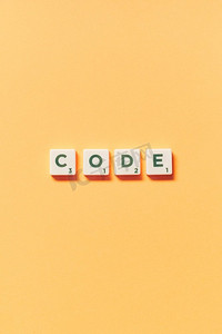 代码字形成的拼字块在黄色背景。创意模板与复制空间..代码形成的拼字游戏块在黄色背景。