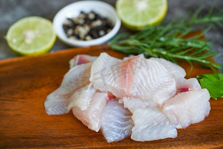 新鲜的生鱼片配肉娃娃鱼罗非鱼条纹鲶鱼鱼片木板配芹菜