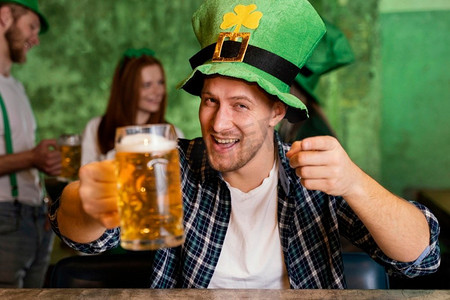 正面视图快乐的人与帽子庆祝圣帕特里克节酒吧