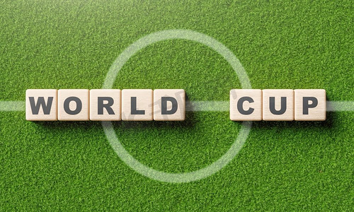 世界杯按钮摄影照片_世界杯字字母在木块立方体在足球场与中心线。体育和比赛的概念。3D插图渲染