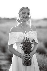 新娘穿着白裙子走在熏衣草的田野上