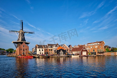 哈莱姆城市景观--斯帕恩河上地标性的风车de Adriaan，有船。荷兰哈莱姆区。荷兰哈莱姆区全景