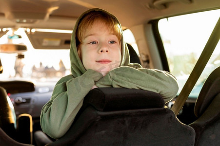 孩子关心爸妈摄影照片_汽车内微笑的孩子，而公路旅行