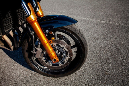 黑色摩托车轮胎摄影照片_前轮胎橙色摩托车