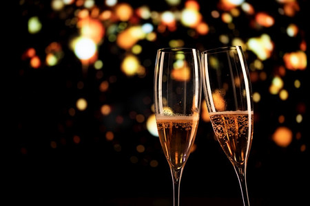 两个香槟酒杯和节日灯光祝新年快乐