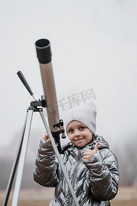 小孩子用望远镜看前景