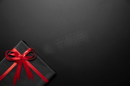 黑色圣诞背景摄影照片_包装黑色礼品与复制空间