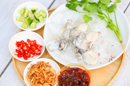 海鲜盘，白底鲜牡蛎，冰牡蛎配柠檬柠檬辣椒酱炒洋葱和海鲜酱泰式食物