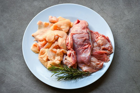 迷迭香食物摄影照片_生鸭胸鸭皮配迷迭香放在盘子里烹调，鲜鸭肉食用