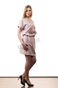 时尚漂亮的女人穿着优雅的休闲粉红色中山装呈现时尚优雅的装备。女性穿着休闲粉红色束腰外衣
