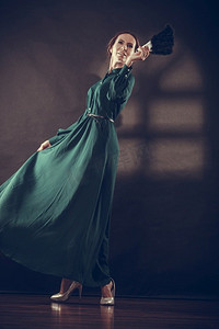复古女性在黑暗中用黑色羽毛扇子跳舞