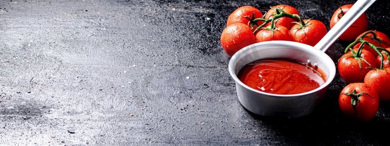 番茄酱和成熟的新鲜西红柿放在树枝上。在黑色背景上。高质量的照片。番茄酱和成熟的新鲜西红柿放在树枝上。
