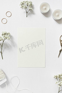 空白卡环绕着玫瑰花结婚戒指串白色背景