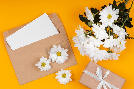 包装礼品摄影照片_各种白色鲜花与信封包装礼品
