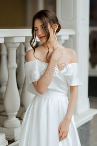一个年轻的新娘女孩在一个短白色连衣裙在雨天的肖像