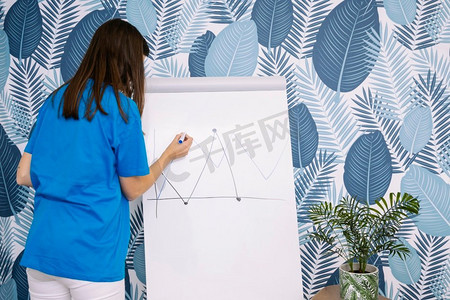 女式蓝色T恤在墙纸上用记号活动挂图作图
