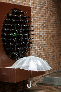 一个透明的打开伞靠近瓶子喷泉