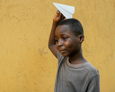 平面小摄影照片_肖像小非洲男孩玩飞机