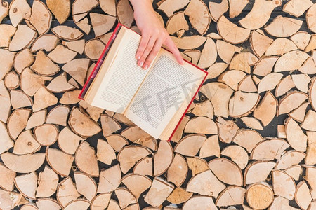 女子S手持书本靠在柴堆墙上