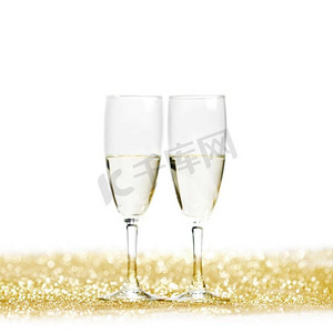 酒杯上的香槟在金色上闪闪发光，孤立在白色上。香槟酒