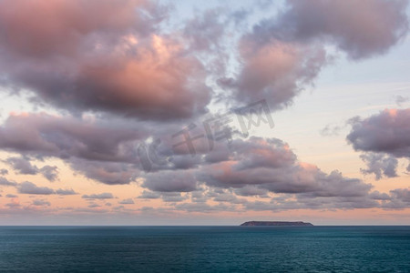 海边蓝天空摄影照片_令人惊叹的日出云的形成和颜色在伦迪岛德文郡海岸在英国在夏末