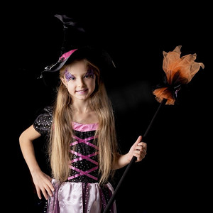 可爱的万圣节女巫女孩在幻想服装，积极的性格，孤立在黑色背景。可爱的万圣节女巫女孩