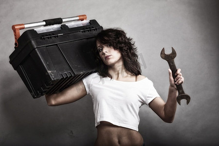 性别平等和女权主义。性感女孩拿着工具箱和扳手工具。从事修理工或技工工作的迷人女性