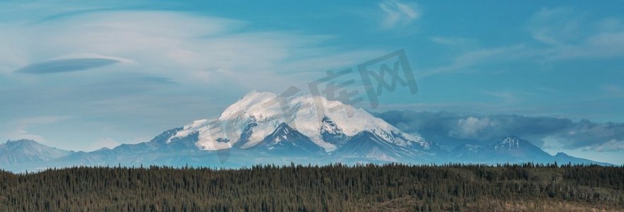 积雪覆盖摄影照片_夏天，风景如画的阿拉斯加山脉。积雪覆盖了地块、冰川和多岩石的山峰。美丽的自然背景。