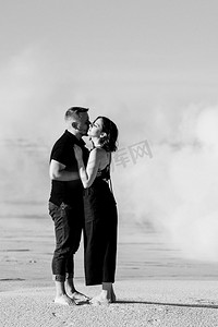 男孩和一个女孩在黑色的衣服拥抱在一个白色的烟雾