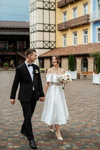 考大学摄影照片_年轻夫妇新娘和新郎在一个白色短礼服走在雨中