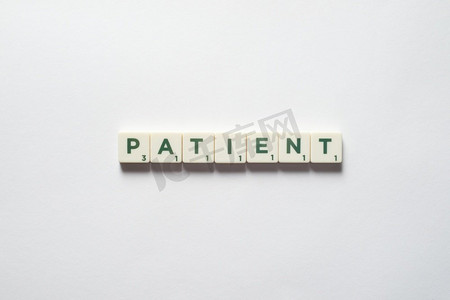 病人字形成的拼字块白色背景。医学检查和身体健康意识。患者由拼字板形成。