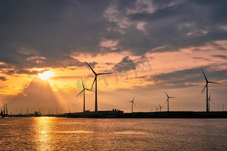 日落时分，安特卫普港的风力涡轮机为发电机供电。比利时安特卫普安特卫普港的风力涡轮机日落。