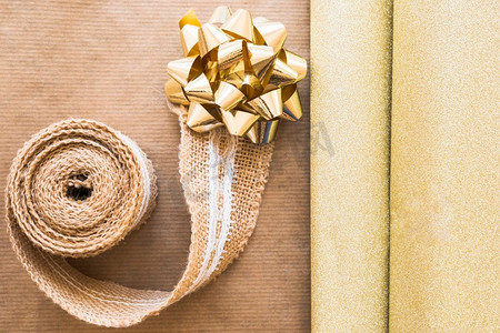 编织框摄影照片_高架视图编织丝带金色蝴蝶结与闪亮的礼品纸