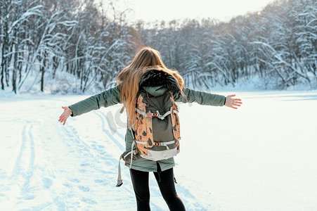 冬日背着背包的女人的背影冰雪爬雪山