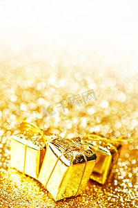 与节日礼物的黄金装饰盒在抽象金背景与白色副本空间。黄金礼盒