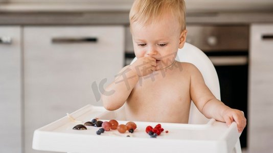 前景可爱的婴儿高脚椅选择吃什么水果