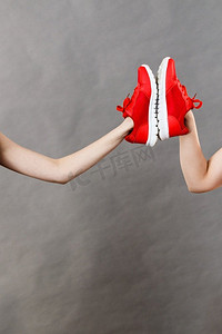 运动鞋展示摄影照片_女士展示运动服运动鞋，红色鞋子，舒适的鞋子，非常适合锻炼和训练。女士展示运动服运动鞋