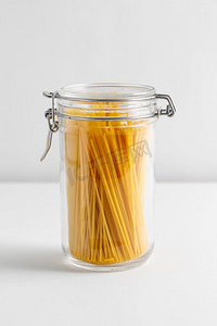食物储存，吃和烹调概念—关闭罐子与意大利面在白色背景关闭的罐子与意大利面在白色桌子