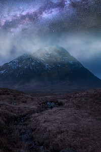冬天银河摄影照片_苏格兰高地雪山景观上令人惊叹的充满活力的银河系合成图像