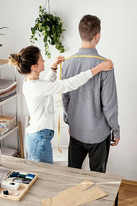 女裁缝测量男性客户衬衫