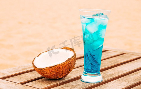 开裂的椰子玻璃亮蓝色饮料木桌