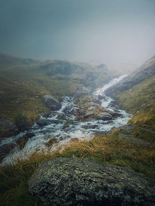 谷雨季摄影照片_在法加拉斯山脉的一个岩石山谷中，山涧快速流过。雨季高水位的河流