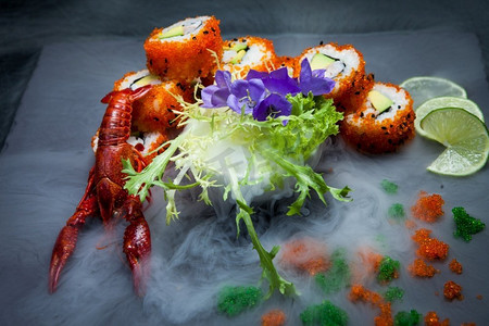 海小龙虾和寿司在石板黑板与液体烟雾