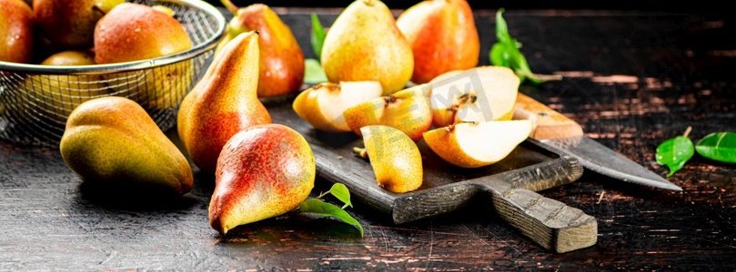 切成片的新鲜梨子放在切菜板上。在黑暗的背景下。高质量的照片。切成片的新鲜梨子放在切菜板上。