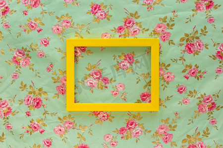 高角度视图黄色空框架反对花卉打印背景