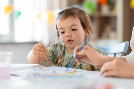 幼儿园家摄影照片_童年，艺术和休闲概念—小女婴在家里或幼儿园绘画。小女婴在家里或幼儿园绘画
