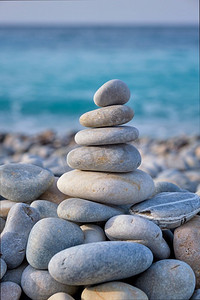 禅定放松概念背景-平衡的石头堆积在海滩上。禅宗平衡的石头堆放在海滩上