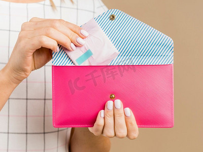 女人拿着垫粉红色钱包