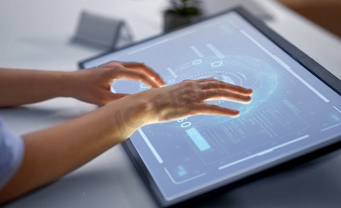技术，虚拟现实和人的概念—手在led光平板电脑或触摸屏在办公室。手在LED灯平板电脑在办公室